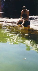 I wonder if the water is cold?  Rob dipping his toes in the water at Gunlom Rockpools.