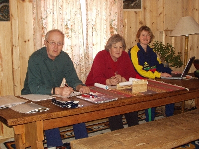 Olav, Janet og Hild arbeider ved langbordet i Systog.