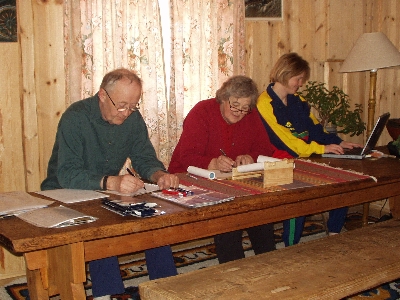 Olav, Janet og Hild arbeider ved langbordet i Systog.