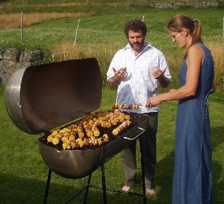 Adelheid working the BBQ while Rob looks on.